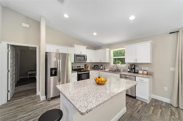 kitchen with a center island, sink, appliances with stainless steel finishes, dark hardwood / wood-style flooring, and white cabinetry