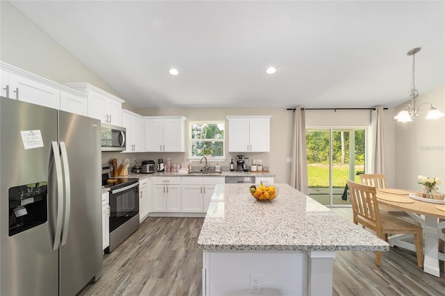 kitchen featuring a healthy amount of sunlight, stainless steel appliances, lofted ceiling, and sink