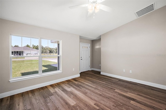 spare room with lofted ceiling, a ceiling fan, visible vents, baseboards, and dark wood finished floors