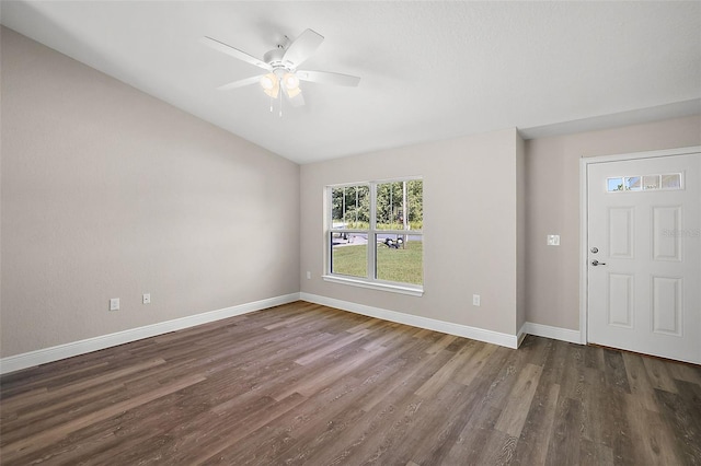 interior space with lofted ceiling, dark wood-style floors, ceiling fan, and baseboards