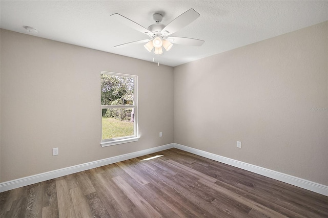 empty room featuring ceiling fan, a textured ceiling, baseboards, and wood finished floors