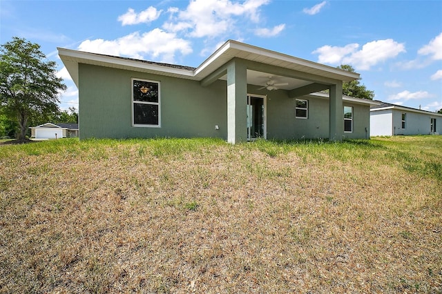 back of house with stucco siding and ceiling fan