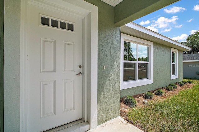 entrance to property featuring stucco siding