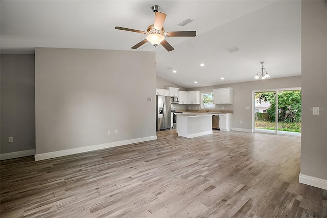 unfurnished living room featuring visible vents, recessed lighting, vaulted ceiling, wood finished floors, and ceiling fan with notable chandelier