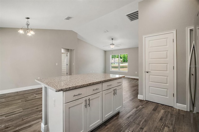 kitchen with white cabinets, visible vents, vaulted ceiling, dark wood finished floors, and ceiling fan with notable chandelier