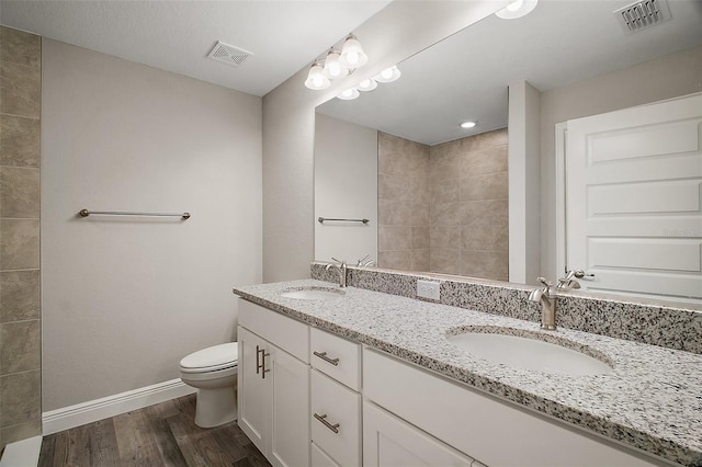 full bathroom featuring visible vents, toilet, and a sink