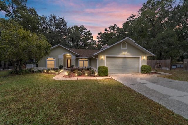 ranch-style house featuring a lawn and a garage