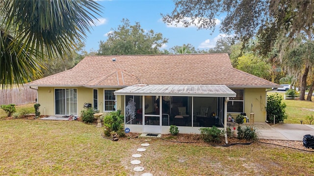 back of house featuring a yard and a sunroom