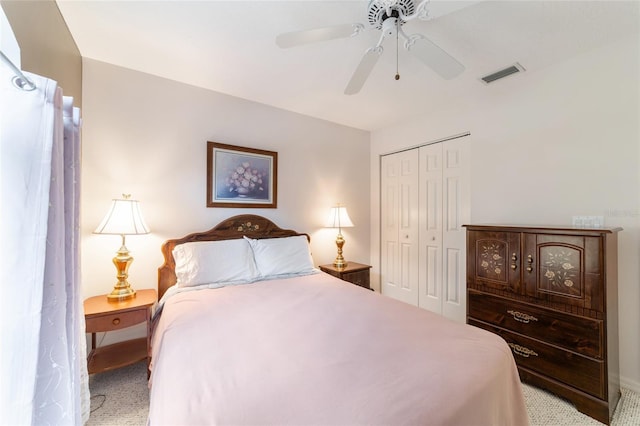 carpeted bedroom with ceiling fan and a closet