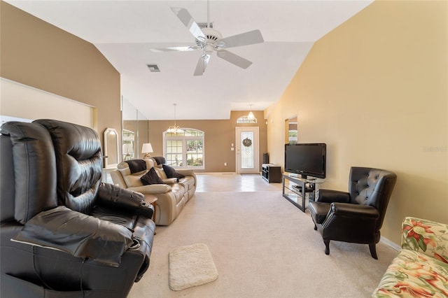 carpeted living room with high vaulted ceiling and ceiling fan with notable chandelier