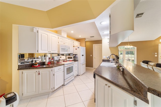 kitchen with white cabinets, white appliances, sink, and a chandelier