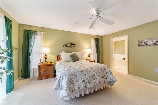 bedroom featuring connected bathroom, ceiling fan, and light carpet