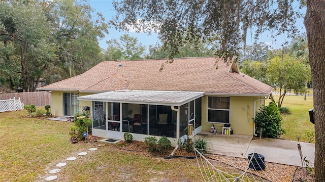 back of property with a patio, a lawn, and a sunroom