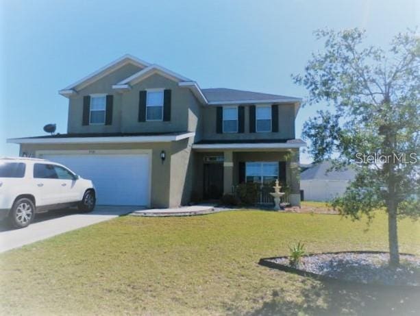 front facade featuring a garage and a front yard