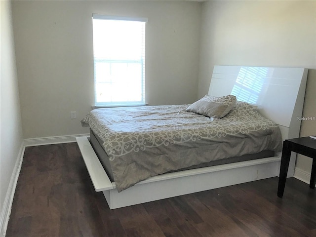 bedroom with dark hardwood / wood-style flooring