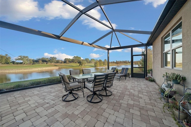 view of patio / terrace with glass enclosure and a water view