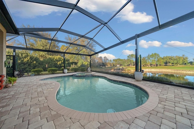 view of pool with an in ground hot tub, a patio, a water view, and glass enclosure