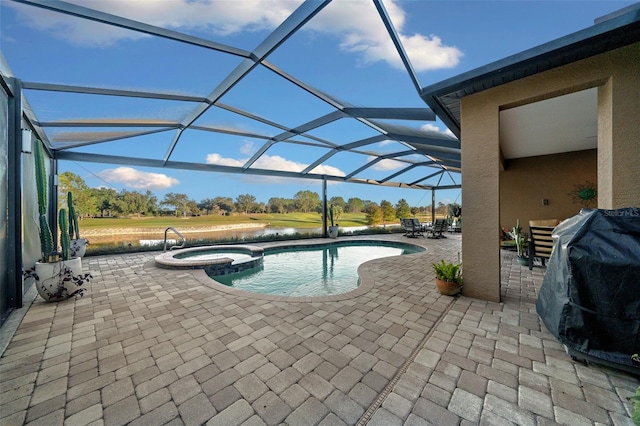 view of pool with an in ground hot tub, a lanai, a patio area, and a grill