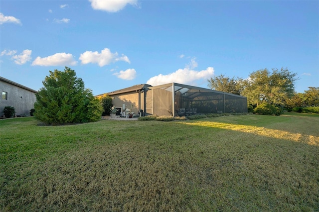 view of yard with glass enclosure and a patio area