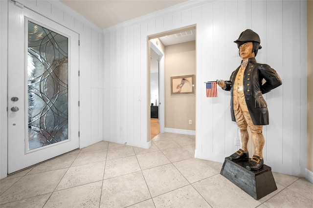 entryway featuring light tile patterned floors and crown molding