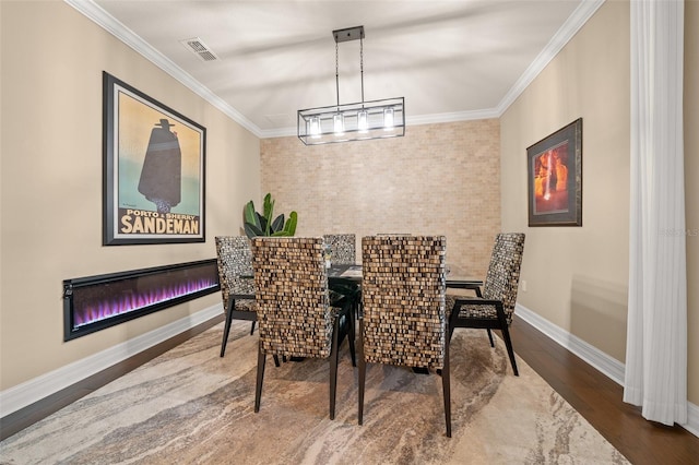 dining room with hardwood / wood-style floors and ornamental molding