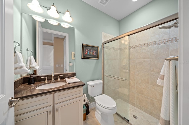 bathroom with tile patterned floors, vanity, toilet, and a shower with shower door