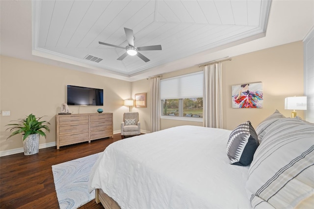 bedroom featuring dark wood-type flooring, crown molding, ceiling fan, a tray ceiling, and wood ceiling