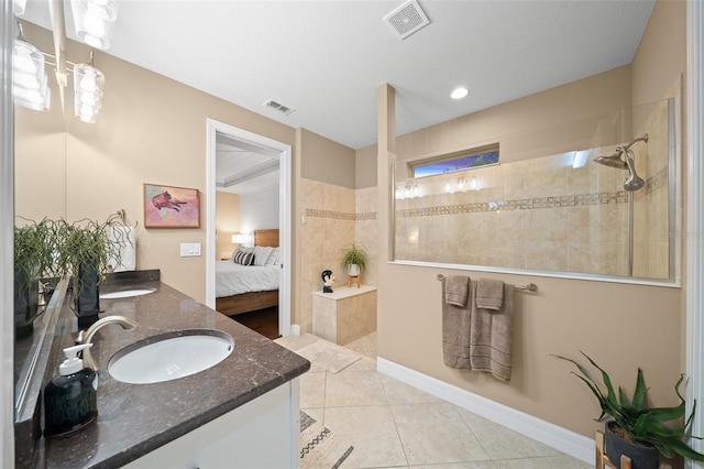 bathroom featuring tiled shower, vanity, and tile patterned floors