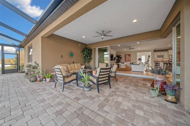 view of patio featuring a lanai, an outdoor living space, and ceiling fan