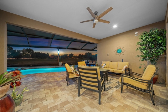 patio terrace at dusk with an outdoor living space, ceiling fan, and a fenced in pool