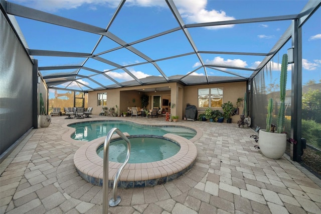 view of swimming pool featuring a patio area, a lanai, and an in ground hot tub