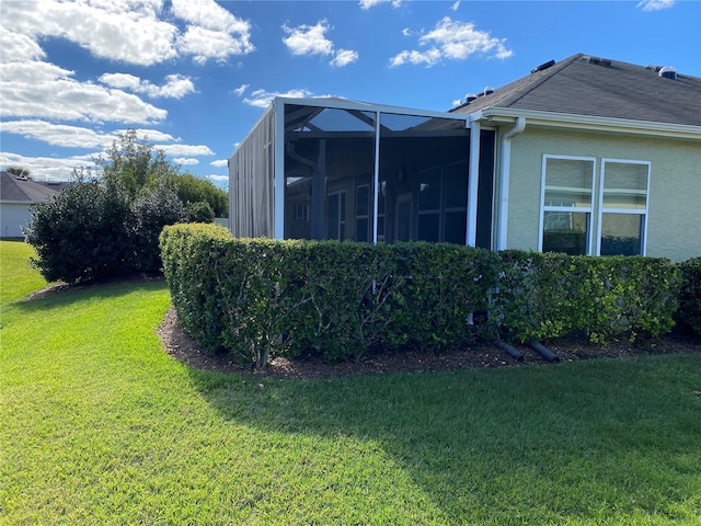 view of side of property featuring a lanai and a lawn