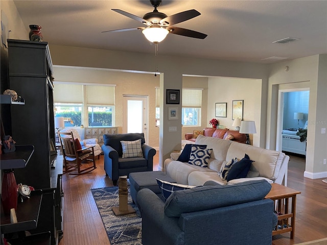 living room featuring ceiling fan and dark wood-type flooring