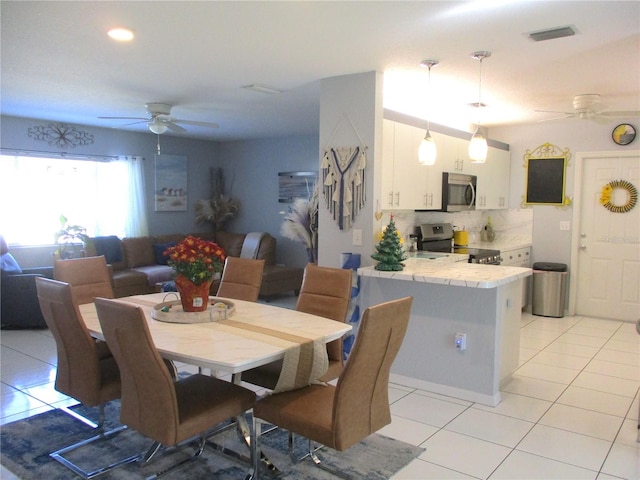 dining space with ceiling fan and light tile patterned floors