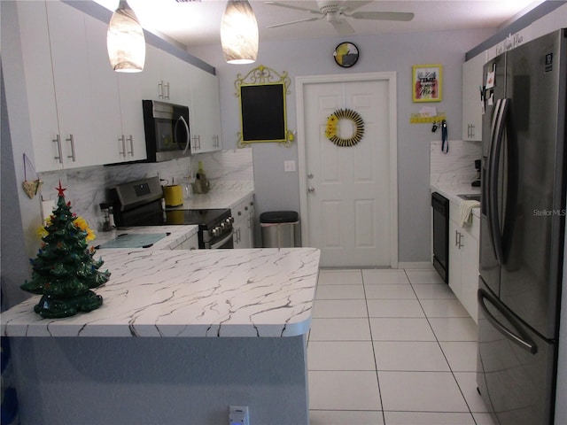 kitchen featuring tasteful backsplash, stainless steel appliances, light tile patterned floors, decorative light fixtures, and white cabinets