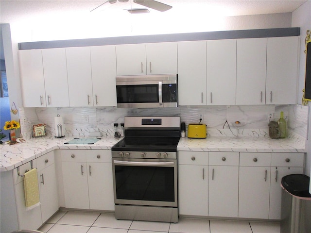 kitchen featuring white cabinets, light tile patterned floors, and stainless steel appliances