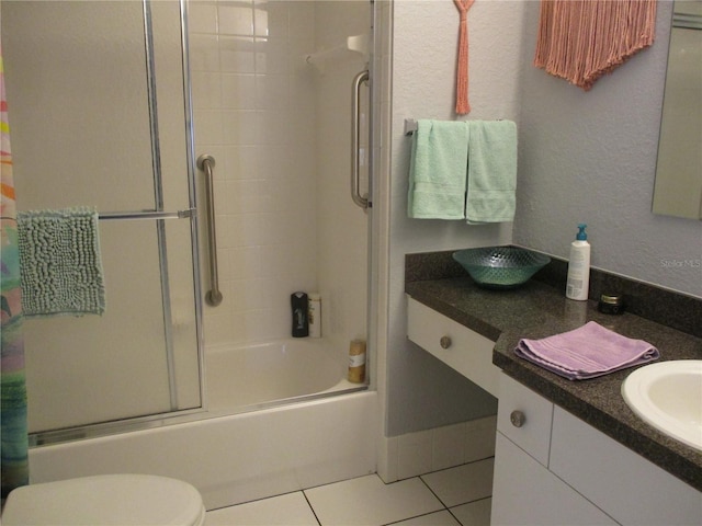 full bathroom with tile patterned flooring, vanity, enclosed tub / shower combo, and toilet