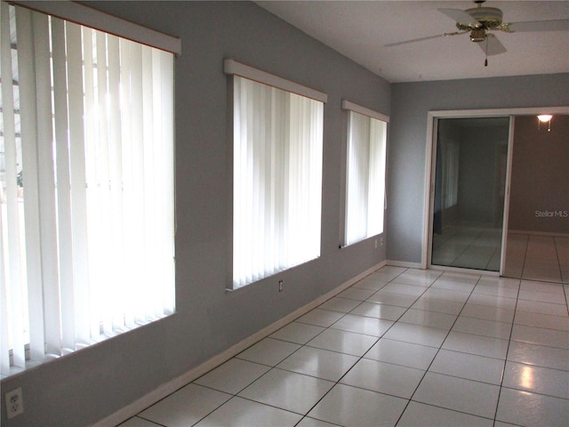 tiled empty room featuring ceiling fan