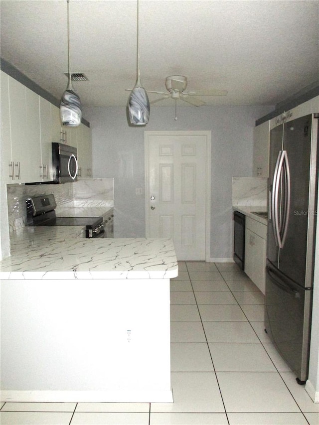 kitchen with stainless steel appliances, light tile patterned floors, hanging light fixtures, and white cabinets