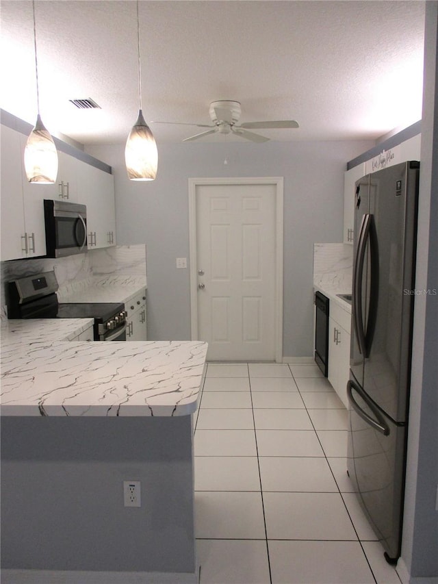 kitchen with white cabinetry, light tile patterned floors, decorative light fixtures, and black appliances