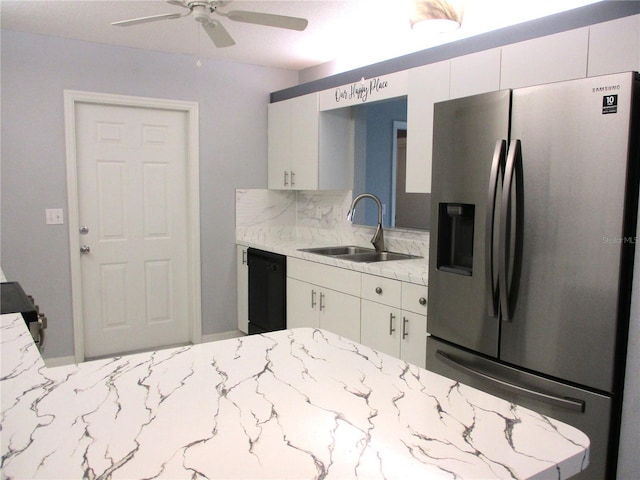 kitchen featuring dishwasher, sink, white cabinets, stainless steel fridge, and light stone counters