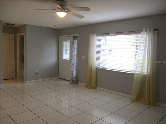 tiled empty room featuring ceiling fan