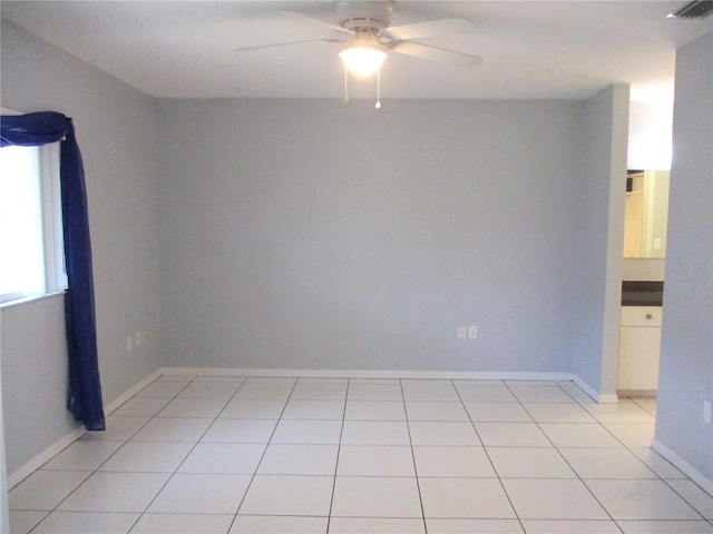 tiled spare room featuring ceiling fan