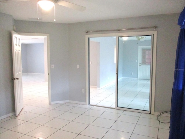 tiled spare room with ceiling fan