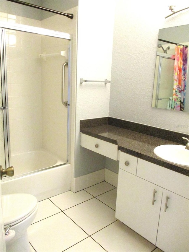 full bathroom featuring shower / bath combination with glass door, tile patterned floors, toilet, and vanity