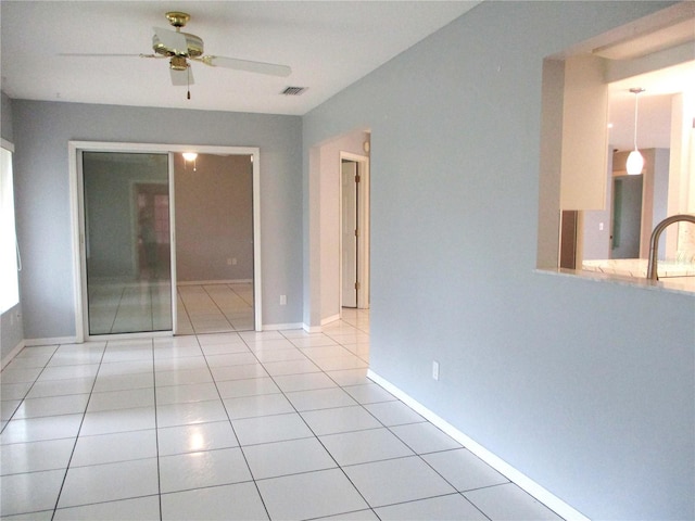 unfurnished room with ceiling fan and light tile patterned flooring