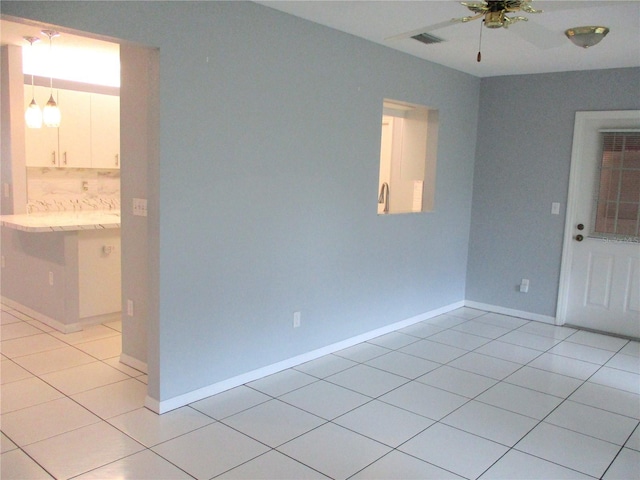 tiled empty room with ceiling fan