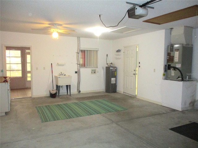 garage with a garage door opener, electric water heater, sink, and heating unit