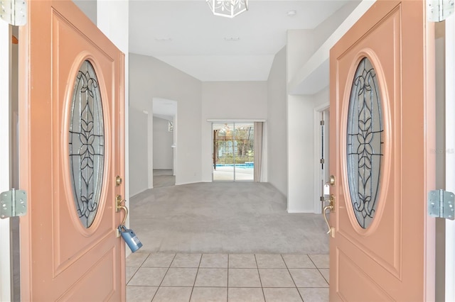 carpeted entrance foyer with vaulted ceiling