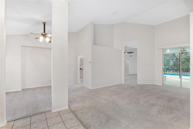 carpeted empty room featuring ceiling fan and high vaulted ceiling